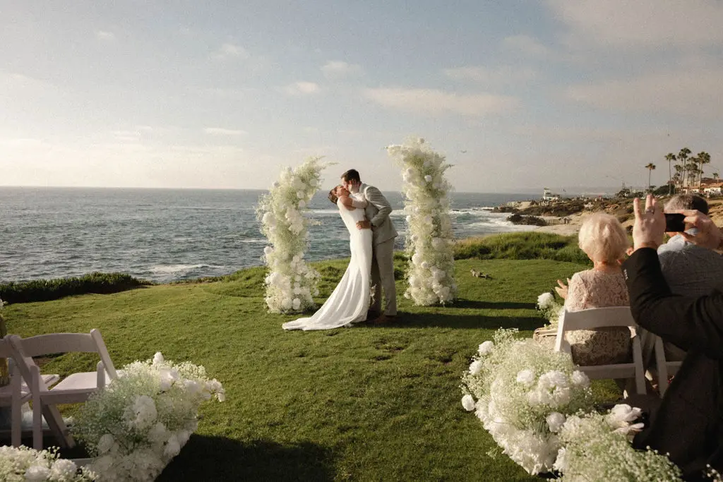 Amber and Tom exchange vows during an oceanfront ceremony at Cuvier Park, The Wedding Bowl, in La Jolla.